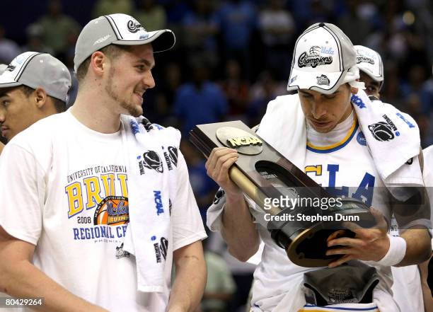 Lorenzo Mata-Rael of the UCLA Bruins holds the West Regional trophy next to teammate Kevin Love following their victory over the Xavier Musketeers in...