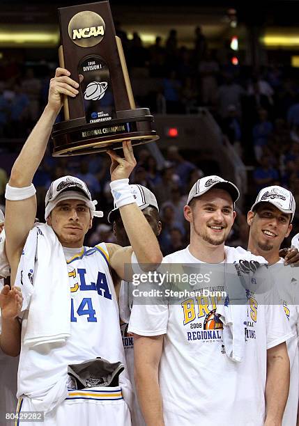 Lorenzo Mata-Rael of the UCLA Bruins holds the West Regional trophy next to teammate Kevin Love following their victory over the Xavier Musketeers in...