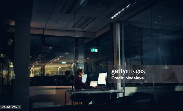 accomplishing his goals no matter the time - dark office stock pictures, royalty-free photos & images