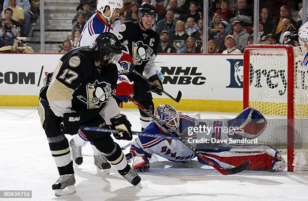 Henrik Lundqvist of the New York Rangers makes a glove save on Petr Sykora of the Pittsburgh Penguins as Sidney Crosby of the Pittsburgh Penguins...