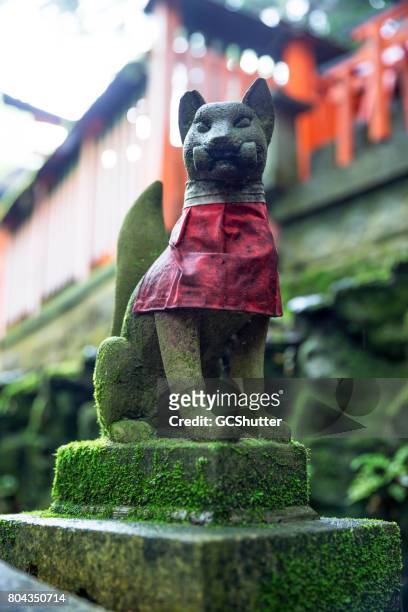 small stone fox positioned on a pedestal at the hiking trail at the fushimi inari-taisha - japanese statue imagens e fotografias de stock