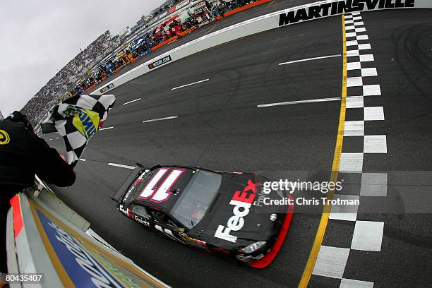 Denny Hamlin, driver of the FedEx Freight Toyota, crosses the finish line to win the NASCAR Sprint Cup Series Goody's Cool Orange 500 at Martinsville...