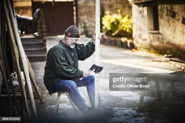 senior man working on piece of wood for making a bow - bow and arrow wood stock pictures, royalty-free photos & images