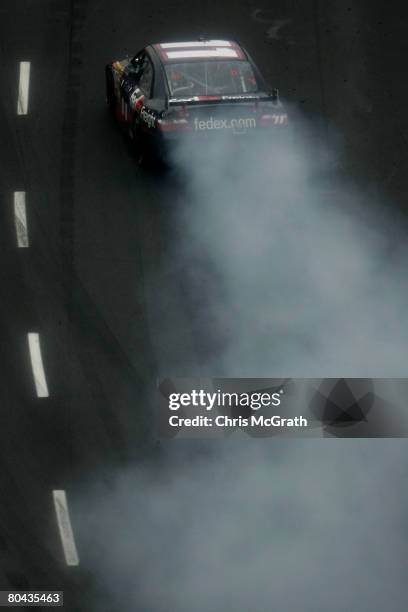 Denny Hamlin, driver of the FedEx Freight Toyota, does a burnout after winning the NASCAR Sprint Cup Series Goody's Cool Orange 500 at Martinsville...