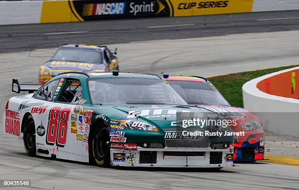 Dale Earnhardt Jr., driver of the AMP Energy/National Guard Chevrolet, and Jeff Gordon, driver of the Dupont Chevrolet, race side by side ahead of...