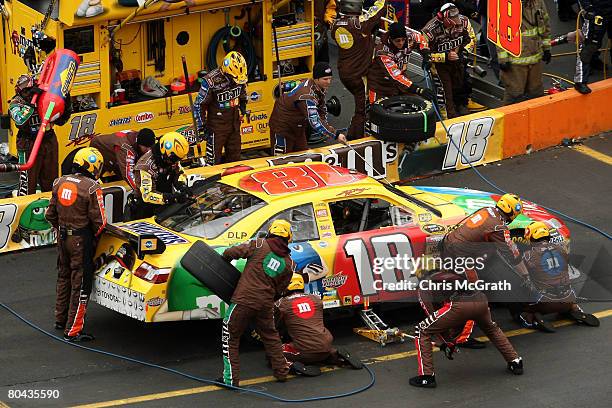 Kyle Busch, driver of the M&M's Toyota, makes a pit stop during the NASCAR Sprint Cup Series Goody's Cool Orange 500 at Martinsville Speedway on...