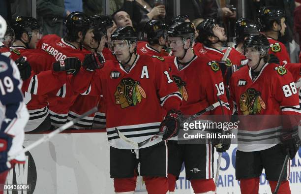 Patrick Sharp of the Chicago Blackhawks celebrates his second period goal against the Columbus Blue Jackets with the bench and teammates Jonathan...