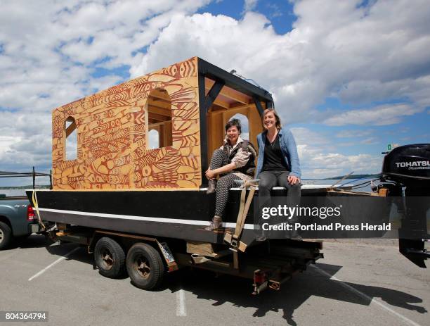 Emily du Houx and Moran Rogers, right, of Carrier Pigeon Studio sit upon the shanty boat/showboat Michi Zeebee, a floating sculpture and boat that...