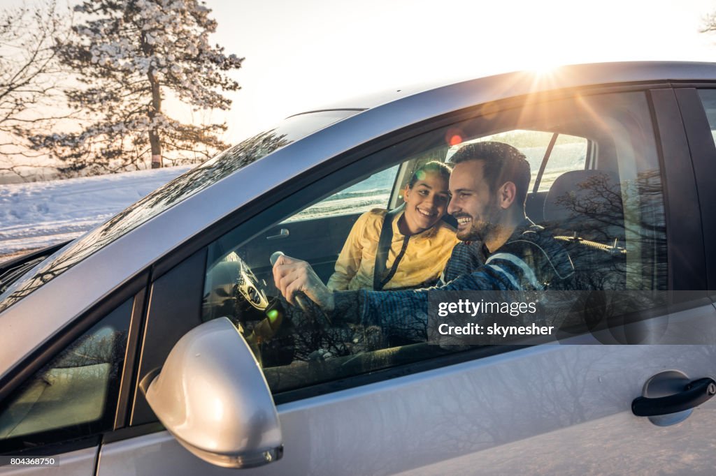 Jeune couple heureux va sur une route se déclenche au cours de la journée d’hiver.