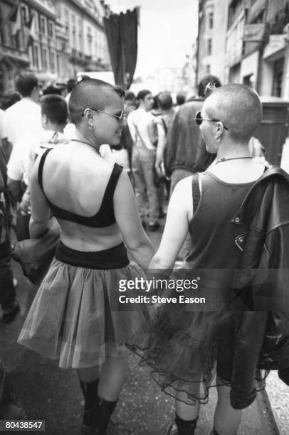 Lesbian couple hold hands during the annual Gay Pride march through central London, 19th June 1993.