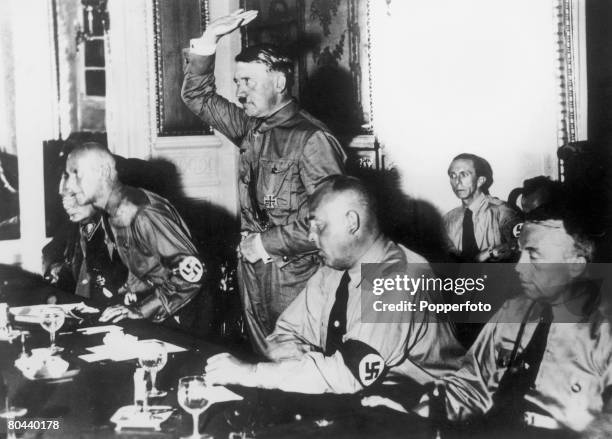 Nazi leader Adolf Hitler , administering an oath to a meeting of 230 Nazi members of the German Reichstag in Berlin, 31st August 1932. From left to...