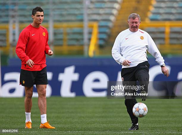 Sir Alex Ferguson, the manager of Manchester United, controls the ball as Cristiano Ronaldo looks on during the Manchester United training session...