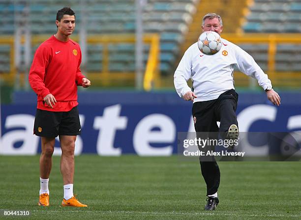 Sir Alex Ferguson the manager of Manchester United controls the ball as Cristiano Ronaldo looks on during the Manchester United training session held...