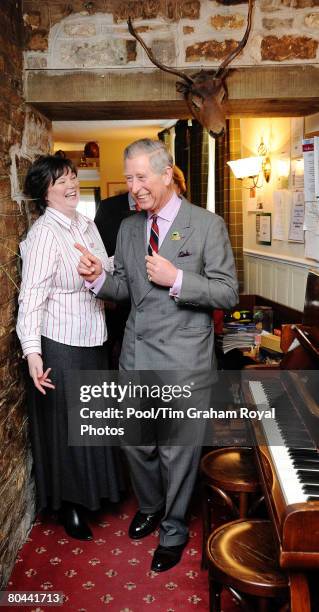 Prince Charles, Prince of Wales walks through the hotel bar with owner Louise Dinnes during a visit to the Black Swan in Ravenstonedale as part of...