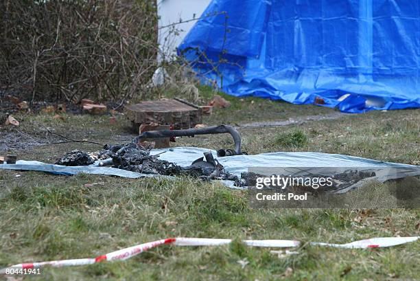 The charred wreckage lays beside a wall after an executive jet crashed, on March 31, 2008 in Farnborough, England. Emergency services have begun to...