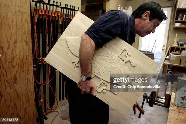 Catholic Deacon and carpenter Dave Cahoon prepares to trim the carved papal seal before putting it into the chair he is building for Pope Benedict...