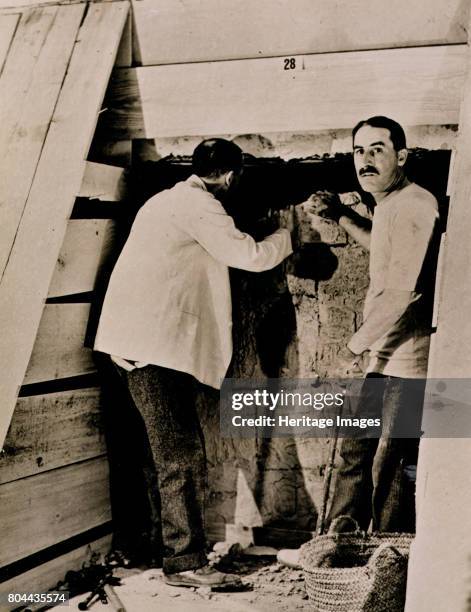 Howard Carter, British archaeologist, in the Valley of the Kings, Egypt, 1922. Carter and a colleague beside a partially demolished wall of one of...