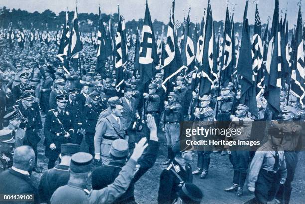 Adolf Hitler, escorted by SS leaders, inspects the SA on a Nazi Party Loyalty Day in Nuremberg, 1933. From Deutsche Gedenkhalle: Das Neue Deutschland...