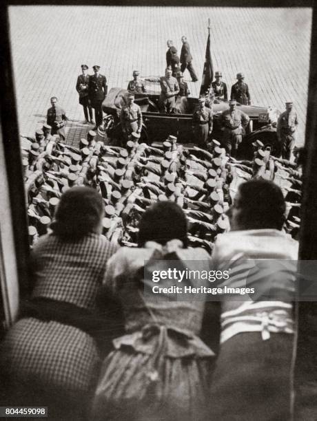 Three girls watching the traditional parade of SA stormtroopers, Nuremberg, Germany, c1923-1938. Adolf Hitler stands in the car reviewing the parade....