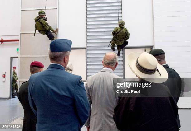 Prince Charles, Prince of Wales is given a demonstration by military personnel during a visit to the Canadian Forces Base Trenton during a 3 day...