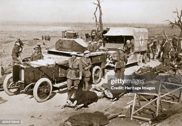British armoured car, near Guillemont, France, Somme campaign, World War I, 1916. Stretcher cases are lying beside the road and an ambulance stands...