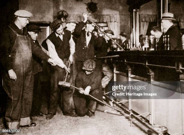 Bar in Camden, New Jersey, being forcibly dismantled by dry agents, USA, 1920s. A scene from the Prohibition era. The sale, manufacture, and...