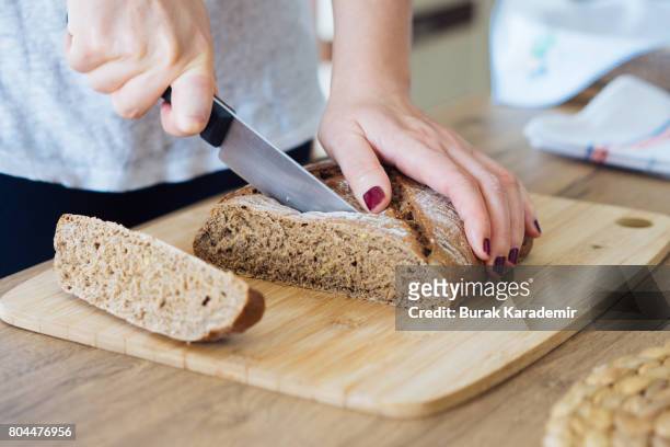 young woman cutting freshly made bread - soda bread stock pictures, royalty-free photos & images