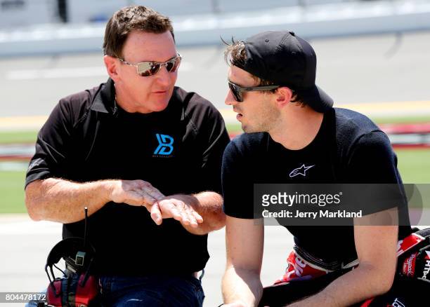 Ben Kennedy, driver of the Rheem Chevrolet, talks with Jimmy Kitchens during qualifying for the NASCAR XFINITY Series Coca-Cola Firecracker 250 at...