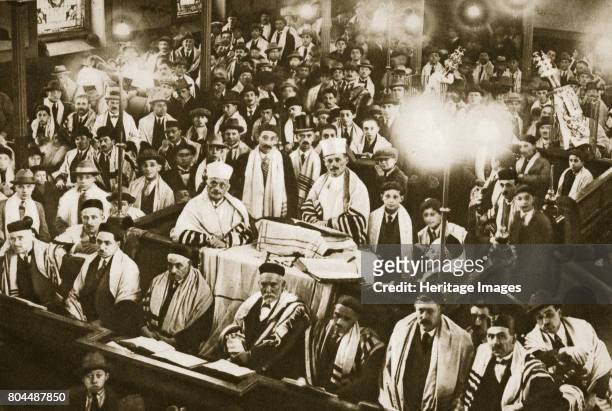 Interior of an East End synagogue during a festival, London, 20th century. The main body of the synagogue is reserved strictly for men, and women are...