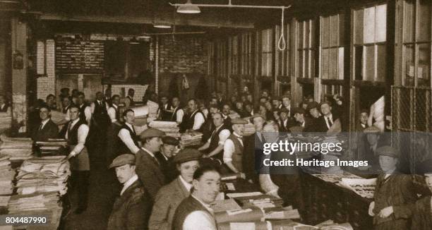 Newsvendors gather to pick up the next day's papers to sell, Carmelite House, London, 20th century. Carmelite House on Fleet Street was the...