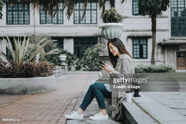 female asian student text messaging on smartphone in campus - taipei tea stock pictures, royalty-free photos & images