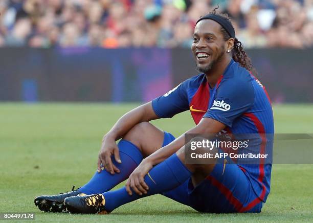 Former Barcelona's Brazilian forward Ronaldinho sits on the field during a charity football match between Barcelona Legends vs Manchester United...