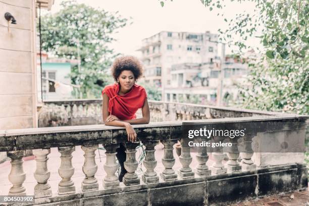 beautiful afro-caribbean cuban woman on balcony in havanna - leaning on elbows stock pictures, royalty-free photos & images