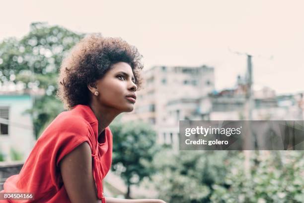 beautiful young afro-caribbean cuban woman on balcony in havanna - leaning on elbows stock pictures, royalty-free photos & images