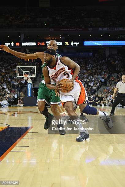 Baron Davis of the Golden State Warriors moves the ball against Ray Allen of the Boston Celtics during the game on February 20, 2008 at Oracle Arena...