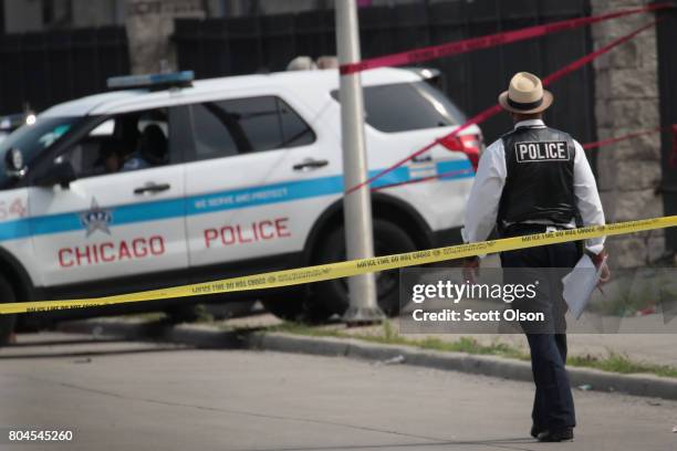 Police investigate the murder of a young man found shot to death in the back seat of a bullet-riddled car on June 30, 2017 in Chicago, Illinois. More...