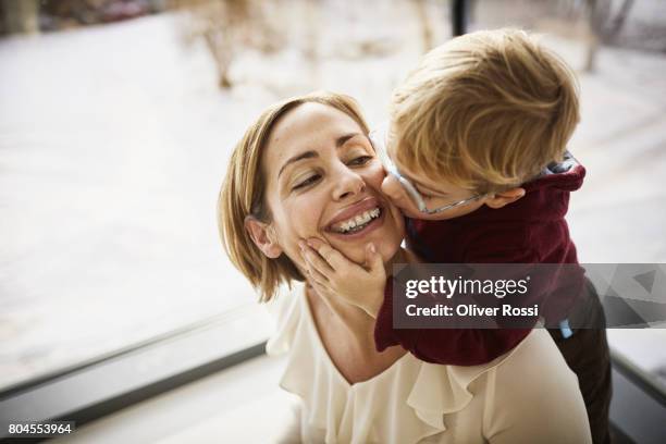 happy mother with son at home - zahnspange frau stock-fotos und bilder