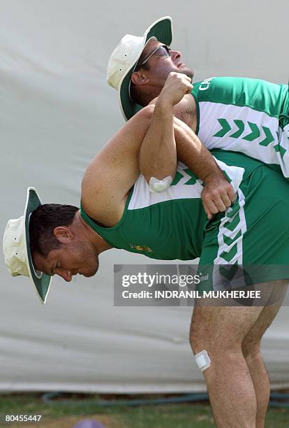 South African cricketers Graeme Smith and Mark Boucher do stretching exercises during a training session ahead of the second Test match between India...