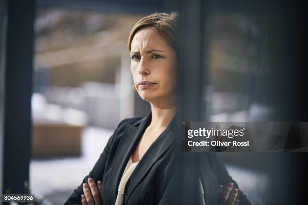 serious businesswoman at the window - disgusto fotografías e imágenes de stock