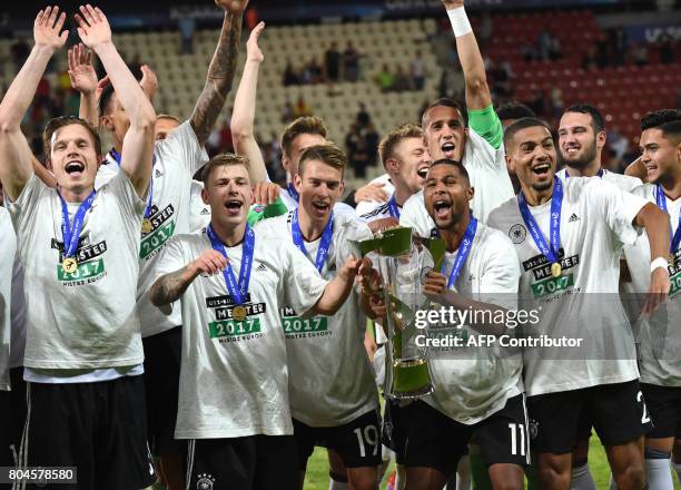 Germany's forward Janik Haberer , Germany's midfielder Serge Gnabry , Germany's defender Jeremy Toljan and teammates celebrate with the trophy after...