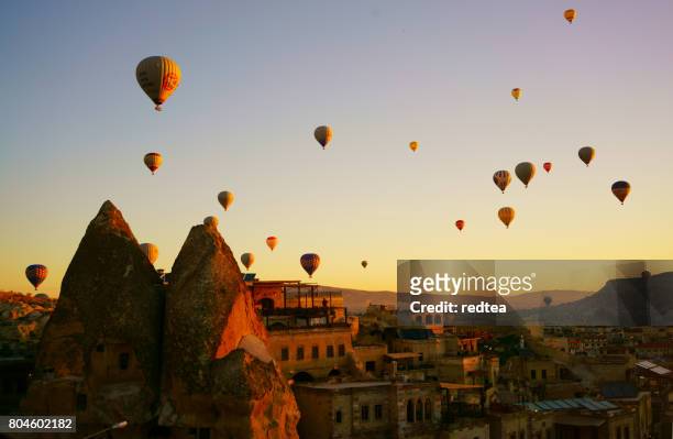 colorful hot air balloons flying over the valley at cappadocia - göreme stock pictures, royalty-free photos & images