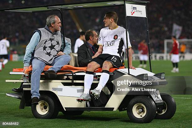 Manchester United's injured defender Nemanja Vidic leaves the pitch by buggy during the UEFA Champions League Quarter Final, first leg match between...