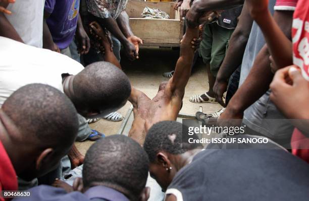 Demonstrators carry the body of a man killed by Ivorian's police on April 1, 2008 when police fired live bullets and tear gas to break up protests...