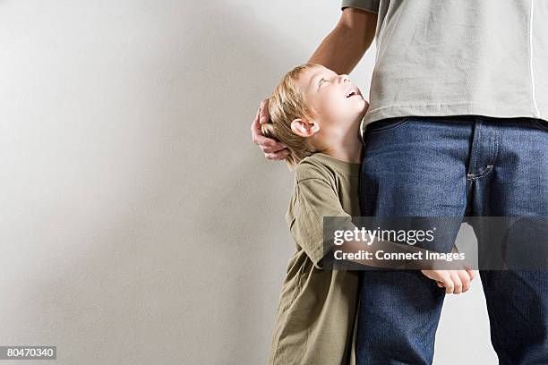 a boy hugging his fathers leg - father son admiration stock pictures, royalty-free photos & images