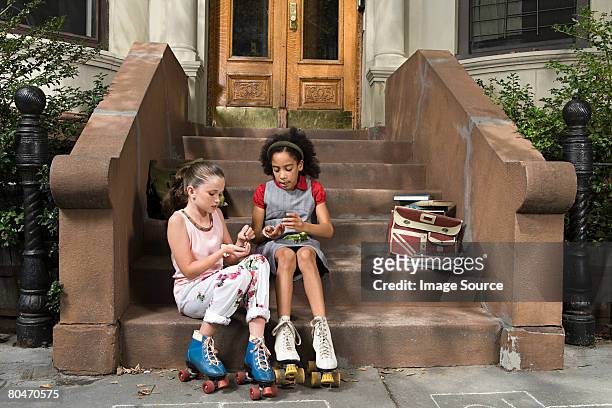 girls sitting on steps - doorstep stock pictures, royalty-free photos & images