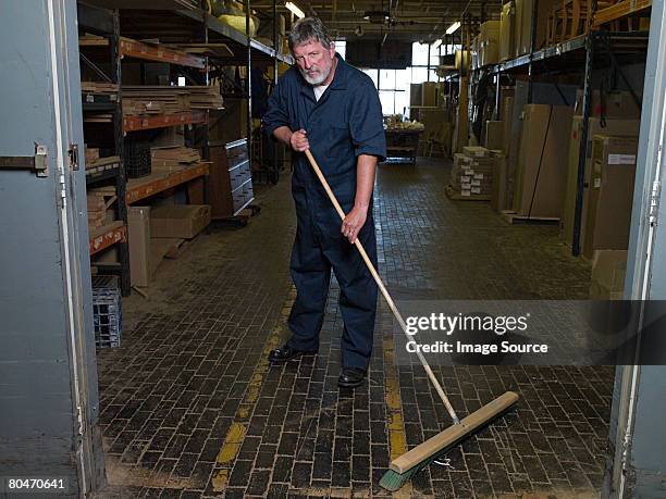 man sweeping a warehouse - sweeping floor stock pictures, royalty-free photos & images