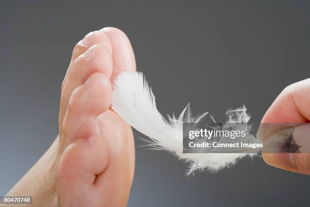 tickling a foot - kitzeln stock-fotos und bilder