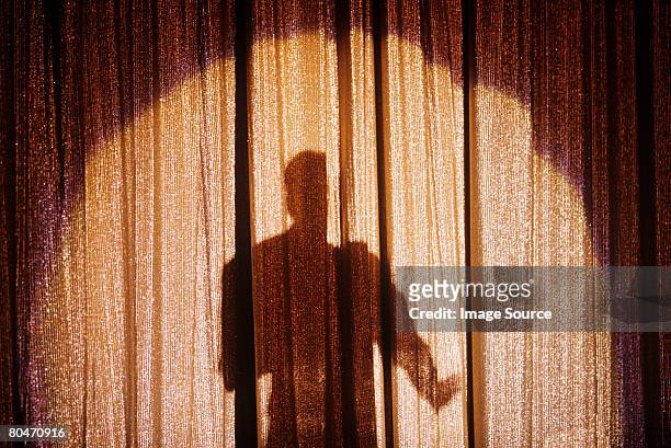 shadow of a person on a stage curtain - schauspieler stock-fotos und bilder