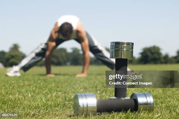 man stretching and dumbbells - dumbbell stock pictures, royalty-free photos & images