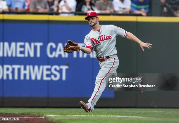 Leftfielder Daniel Nava of the Philadelphia Phillies fields a fly ball during an interleague game against the Seattle Mariners at Safeco Field on...